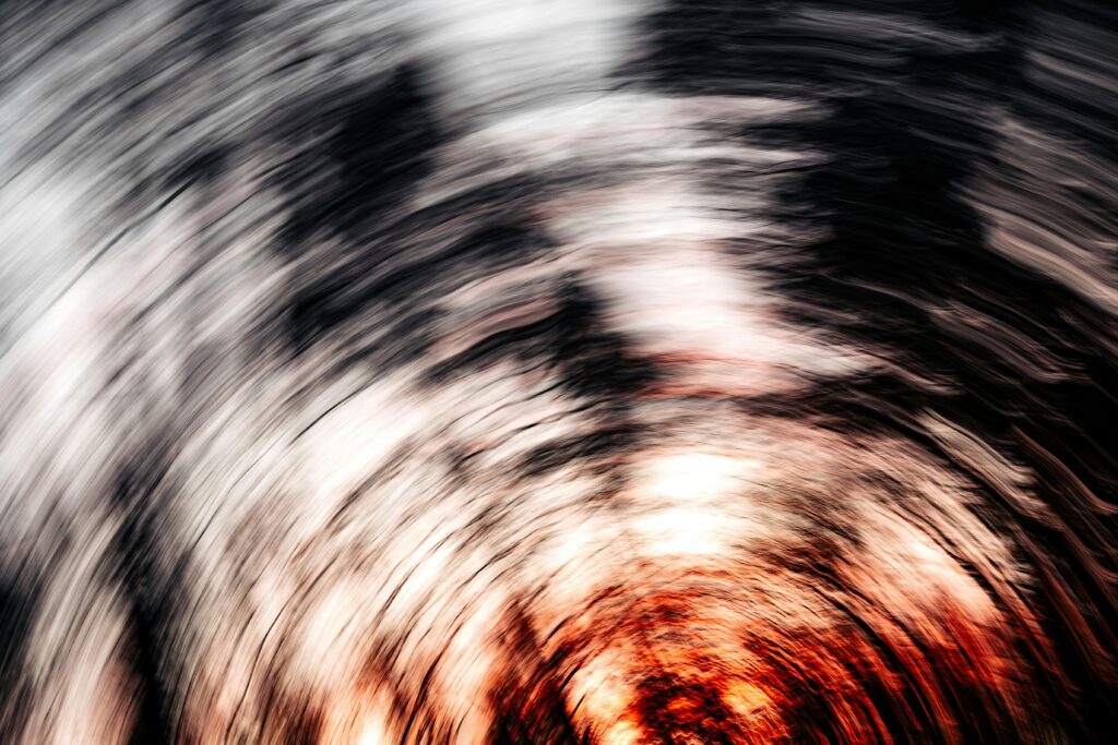 Dynamic abstract image depicting swirling lines with fiery red and black textures creating a vortex effect.